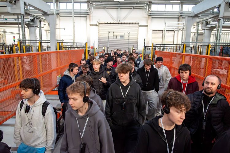 młodzież ze słuchawkami na uszach w fabryce