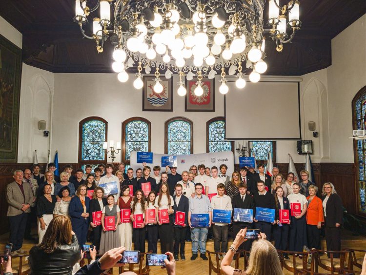 młodzież stoi na podwyższeniu w sali ratusza w Słupsku